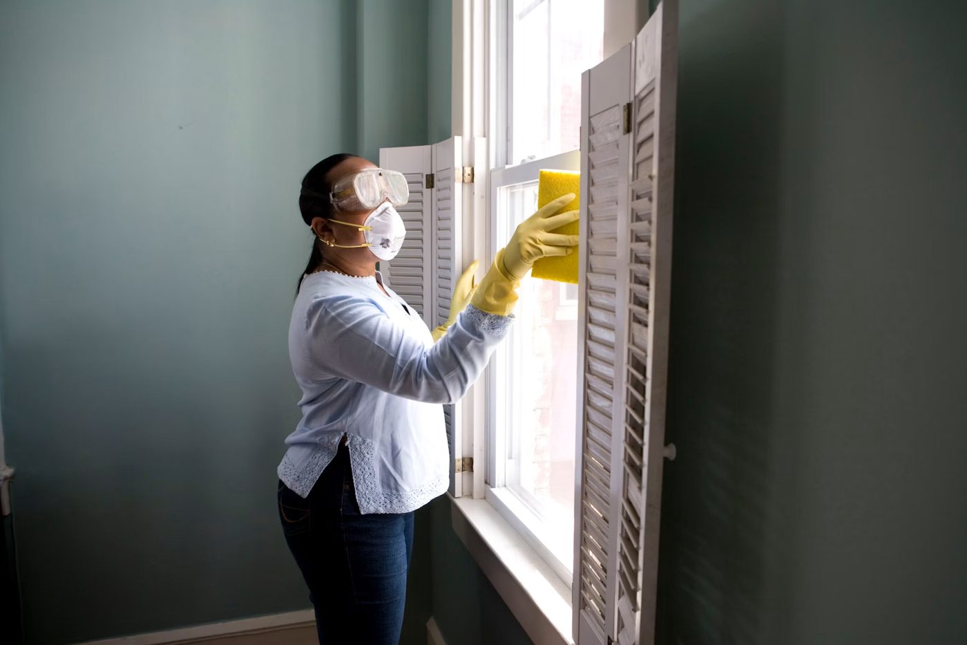 Cleaning professional with protective mask and goggles removing fine construction dust in Fairfield County CT
